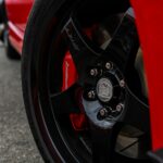 Detailed close-up of a red car wheel highlighting the sporty design and branding.