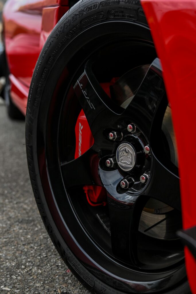 Detailed close-up of a red car wheel highlighting the sporty design and branding.